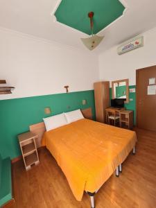 サン・ジョヴァンニ・ロトンドにあるB&B Santa Luciaの緑の壁の客室の大型ベッド1台