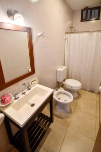 a bathroom with a sink and a toilet and a mirror at Apartamentos Ref in Salta