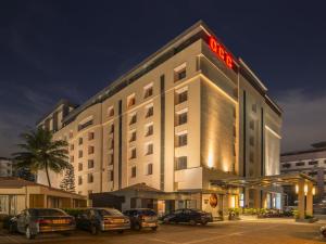 a hotel with cars parked in a parking lot at GCC Hotel and Club in Mumbai