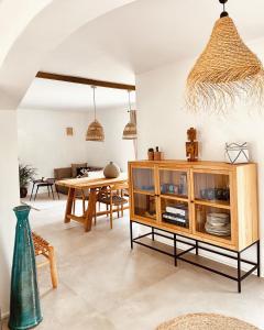 a dining room with a table and a wooden cabinet at Can Yuca II in Cala Mondrago
