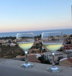dois copos de vinho branco sentados numa saliência em Casa Luna - Sea view apartment Bolnuevo em Bolnuevo