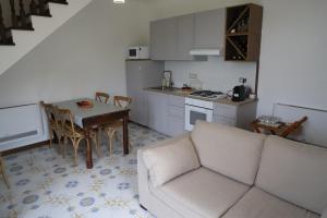 a living room with a couch and a table and a kitchen at B&B Il borgo incantato in Laureana Cilento