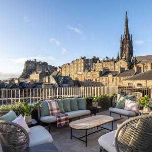 patio con divani, sedie e vista sulla città di Virgin Hotels Edinburgh a Edimburgo