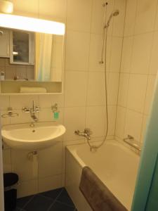 y baño con lavabo, bañera y ducha. en Studio flat in the heart of Zug, ideal for solo travellers, en Zug
