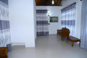 a living room with two benches and curtains at Berty's Cottage in Jaffna