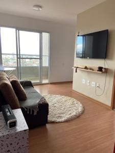 a living room with a couch and a flat screen tv at AP Novo Mobiliado in Salvador