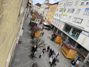 a group of people walking around a street in a city at BRS22 Rooms in Győr