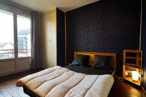 ein Schlafzimmer mit einem großen Bett und einem Fenster in der Unterkunft Bright and cosy flat - Alliés #ER in Grenoble