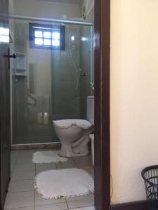 a bathroom with a glass shower and a toilet at Chalés Rio Bonito in Imbassai