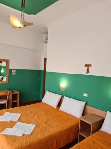 a room with two beds and a green wall at B&B Santa Lucia in San Giovanni Rotondo