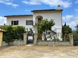 een groot wit huis met een stenen muur bij B&B La Loccaia in Ciggiano