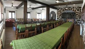 a dining room with green tables and chairs and a fireplace at Casa Rural El Batán Casa rural 37 personas in Toledo