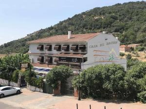 a white building with a mountain in the background at Casa Rural El Batán Casa rural 37 personas in Toledo