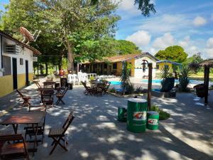un patio con mesas y sillas junto a una piscina en PANTANAL SANTA CLARA en Corumbá