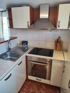 una pequeña cocina con fogones y fregadero en Sweet Apartments, en Makarska