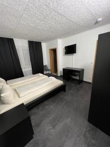 a bedroom with two beds and a flat screen tv at Hotel Dümptener Hof in Mülheim an der Ruhr