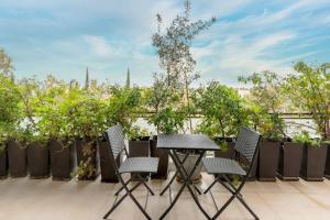 a table and chairs on a patio with a view at Panoramic 1BR Apartment near Kallimarmaro Stadium by UPSTREET in Athens
