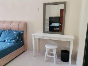einen weißen Schminktisch mit einem Stuhl und einem Spiegel in der Unterkunft Eng Ban Hin guesthouse in Malakka