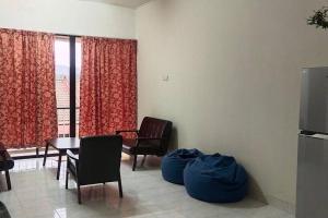 ein Wohnzimmer mit Stühlen, einem Tisch und einem TV in der Unterkunft Eng Ban Hin guesthouse in Malakka