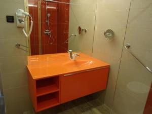 y baño con lavabo de color naranja y ducha. en Fedrig Rooms with bathroom & Hostel Rooms, en Kobarid