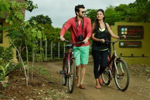 a man and a woman riding bikes on a trail at Asiatic Lion Lodge in Sasan Gir