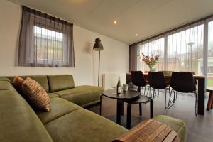 a living room with a couch and a table at Recreatiepark Jachthaven De Veerstal Lathum - Luxe Chalet in Lathum