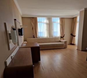 a living room with a couch and a large window at Azak Hotel in Alanya