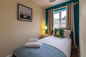 a small bedroom with a bed and a window at Heron House 2 Bedrooms, Private Garden FREE PARKING, Close to City, Hospital and Uni Long Stays Welcome in Nottingham