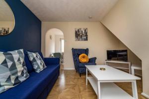 a living room with a blue couch and a table at Heron House 2 Bedrooms, Private Garden FREE PARKING, Close to City, Hospital and Uni Long Stays Welcome in Nottingham