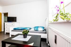 Habitación pequeña con 2 camas y mesa. en Messewohnung Buchforst en Colonia