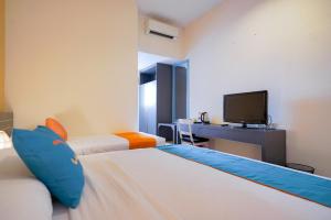 Postel nebo postele na pokoji v ubytování Sans Sunset Point Seminyak