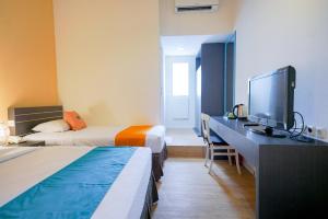 Postel nebo postele na pokoji v ubytování Sans Sunset Point Seminyak