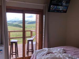 カンバラにあるVale de cambara Iのベッドのある寝室と、スツールが2つあるバルコニー