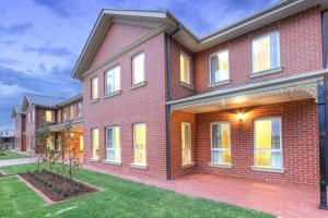 a red brick house with a yard at Best Western Plus Bolton on the Park in Wagga Wagga