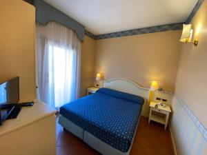 a small bedroom with a blue bed and a window at Il Ghebo in Cavallino-Treporti