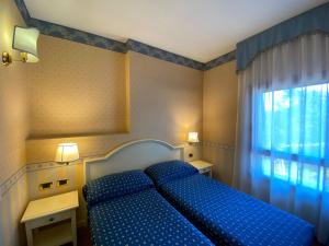 a bedroom with a blue bed and a window at Il Ghebo in Cavallino-Treporti