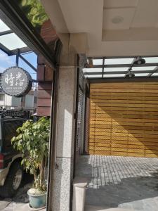 budynek z drewnianymi drzwiami garażowymi z rośliną w obiekcie Time House w mieście Hualian
