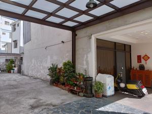 ein Gebäude mit einem Roller, der vor einer Garage geparkt ist in der Unterkunft Time House in Hualien