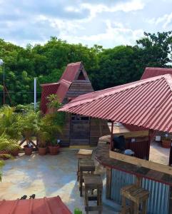 eine Terrasse mit einem Gebäude mit rotem Dach in der Unterkunft Tinyhouse samaná 