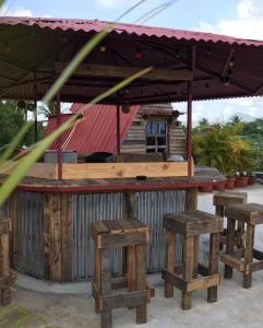 een bar met vier houten krukken ervoor bij Tinyhouse samaná 