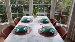 a table with chairs and plates and wine glasses at dutchduochalet13 in s-Gravenzande