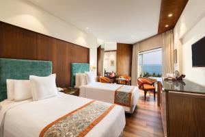 a hotel room with two beds and a television at Welcomhotel by ITC Hotels, Devee Grand Bay, Visakhapatnam in Visakhapatnam