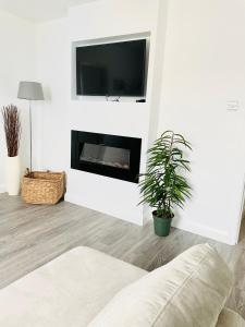 a living room with a fireplace and a tv on a wall at Harbour View Killybegs in Killybegs