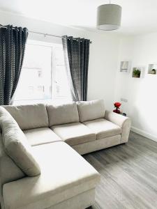 a living room with a white couch and a window at Harbour View Killybegs in Killybegs