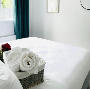 a basket of white towels sitting on a bed at Harbour View Killybegs in Killybegs