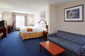 Habitación de hotel con cama y sofá en Holiday Inn Express Hotel & Suites Cleveland-Richfield, an IHG Hotel, en Brecksville