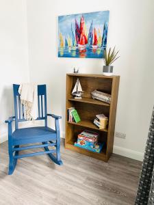 a blue chair in a room with a book shelf at Harbour View Killybegs in Killybegs