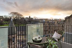 a balcony with a table and chairs and a view of a city at Virgin Hotels Edinburgh in Edinburgh