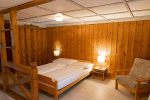 1 dormitorio con 1 cama y 1 silla en Gasthof Bären en Habkern