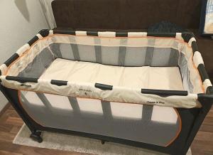 an empty baby crib with the top open at Kurstadt Apt Moderne 2ZKB Balkon-PKW- Stellplatz Check-in 7-24 h in Bad Nauheim
